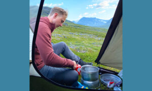 Byggprojektledare Marcus Källbrink lagar mat på Trangiakök vid sitt tält i fjällen.